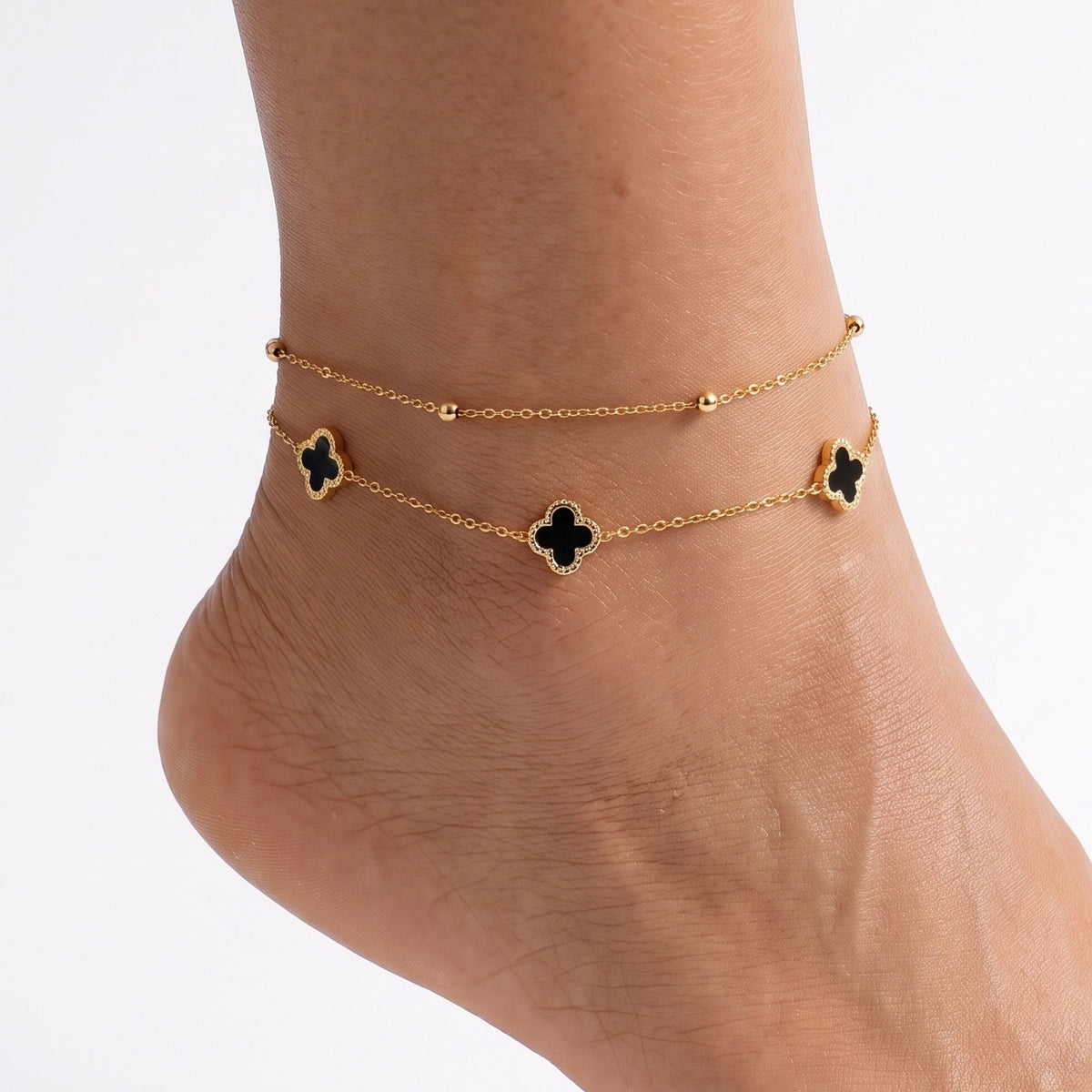 Ankle wearing Lelice gold black clover layered anklet Lise