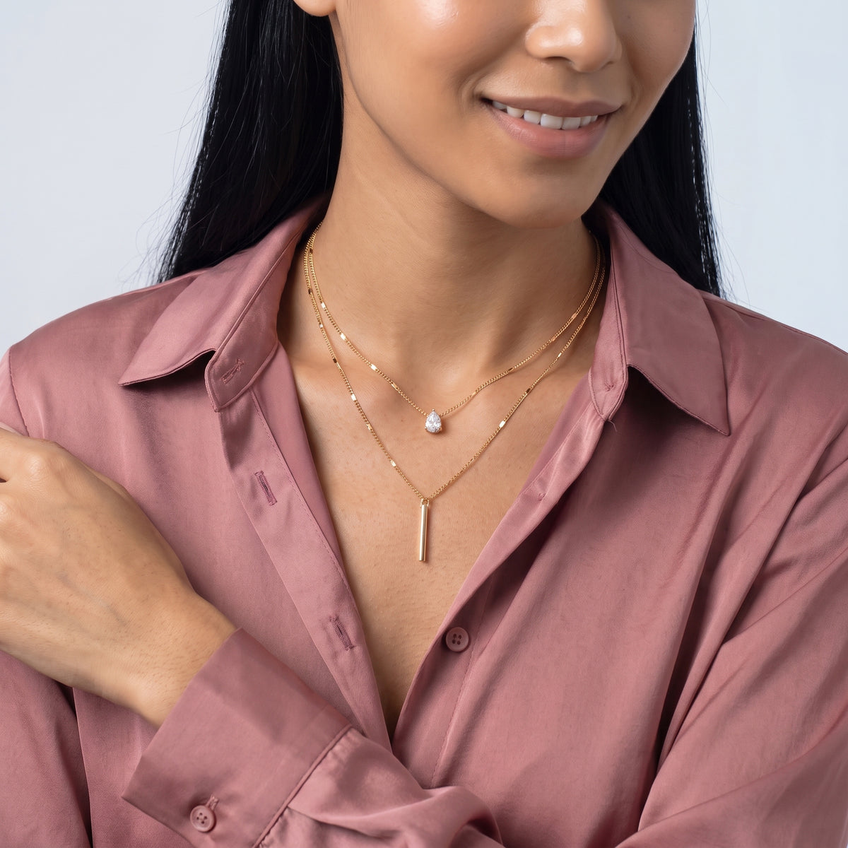 Woman with head tilted down wearing the Livia Layered Necklace Set