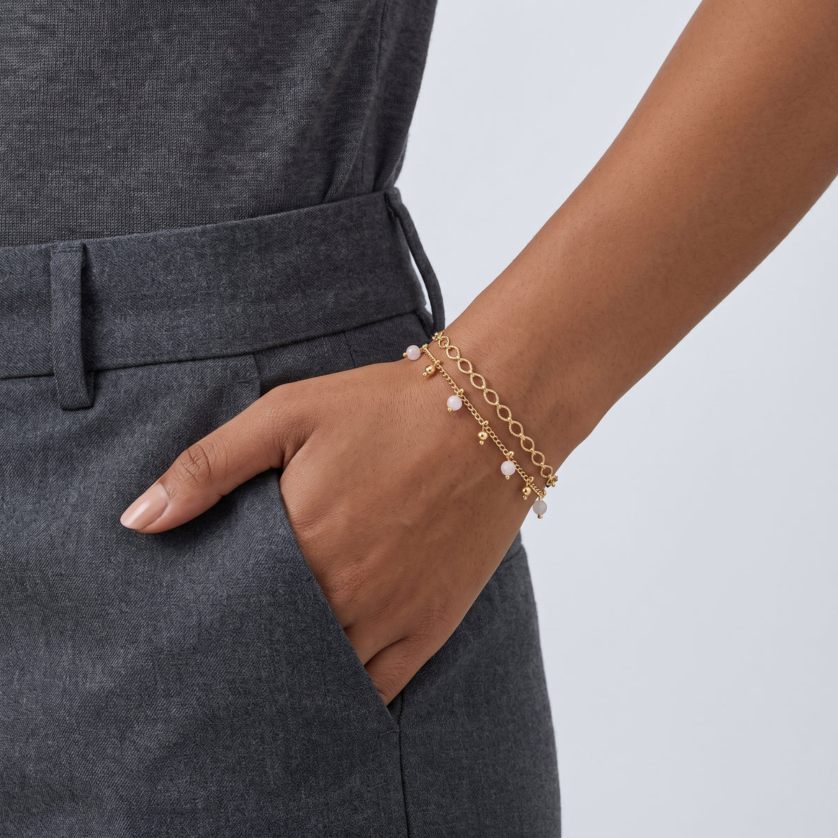 Model wearing the Lelice Lola Charm Bracelet in gold, hand in the trouser pocket