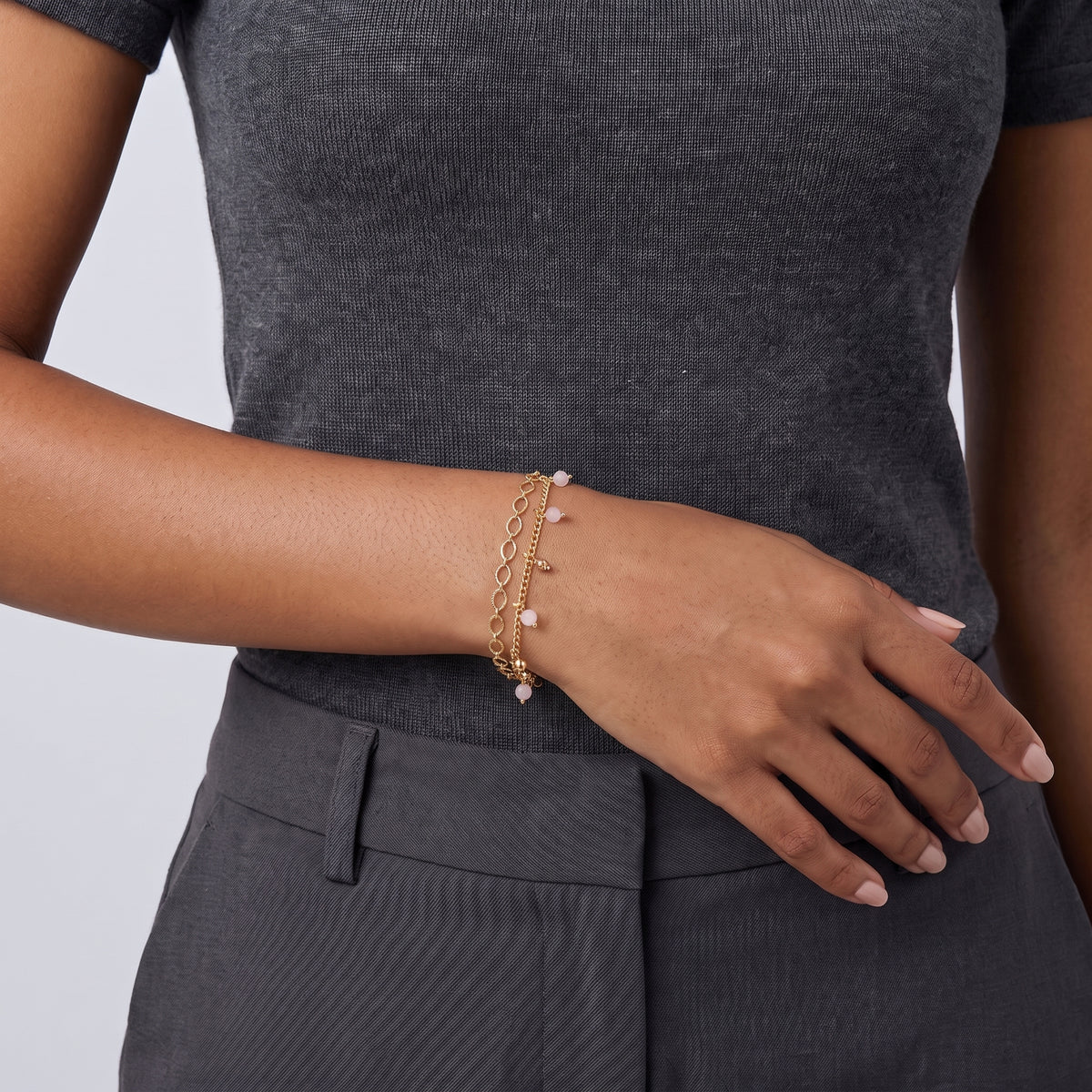 Model wearing the Lelice Lola Charm Bracelet in gold, hand resting at the waist