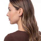 Three-quarter back view of woman wearing Lola gold flower studs