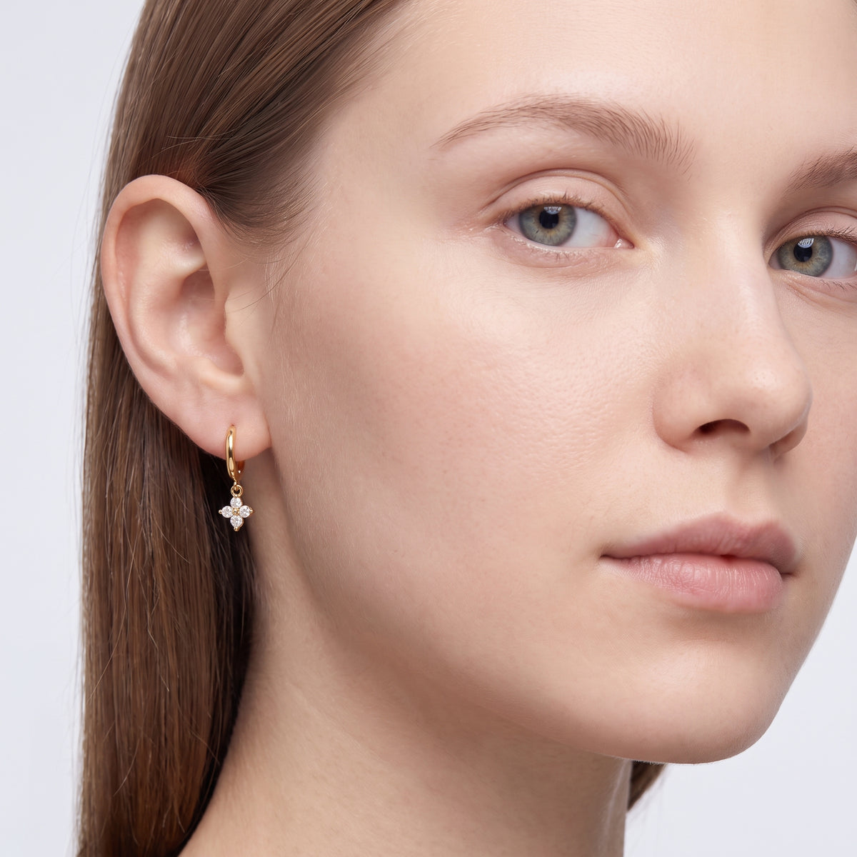 Model wearing the Lelice Lou Clover Earrings in gold, three-quarter face close-up