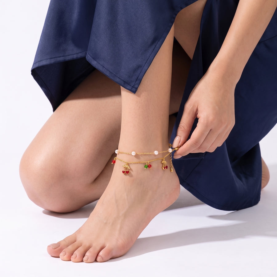 Hand resting on the shin above the Louise Cherry Anklet