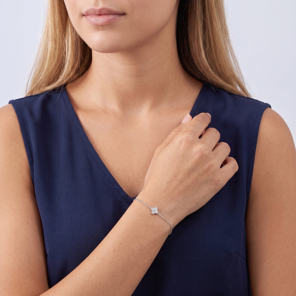 Model wearing the Lelice Louise Clover Bracelet in silver, hand at the collar