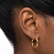 Close-up of the Lelice Lucy Round Hoops in gold on the ear