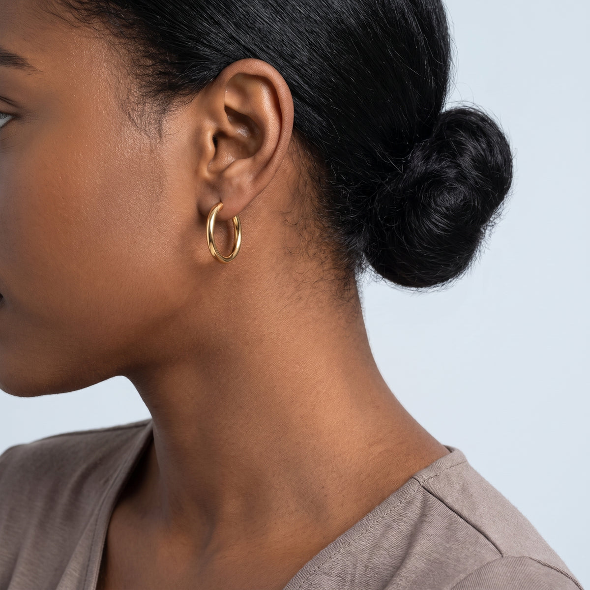 Model wearing the Lelice Lucy Round Hoops in gold, low bun, ear and neck