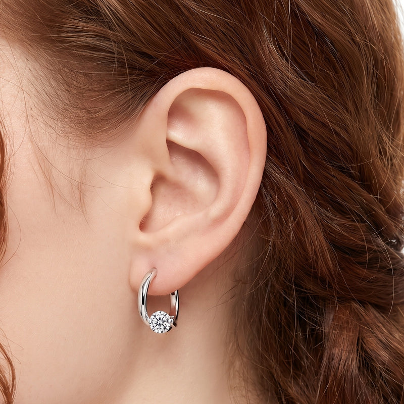 Close-up of the Lelice Maëlle Silver Solitaire Huggies on the ear
