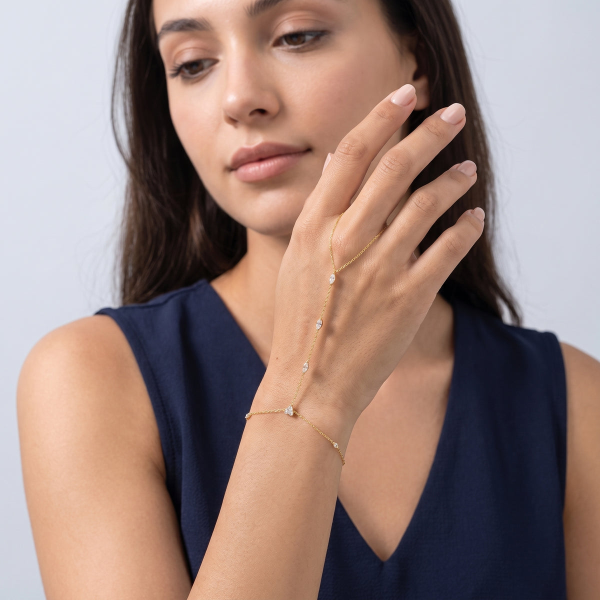 Model wearing the Lelice Margaux Sparkle Bracelet in gold, hand in front of the face