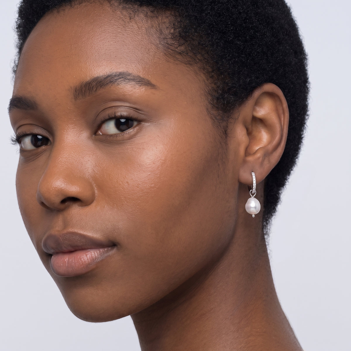 Model wearing the Lelice Margo Silver Huggies, three-quarter face close-up