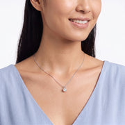 Woman with head tilted down wearing Marianne silver solitaire necklace