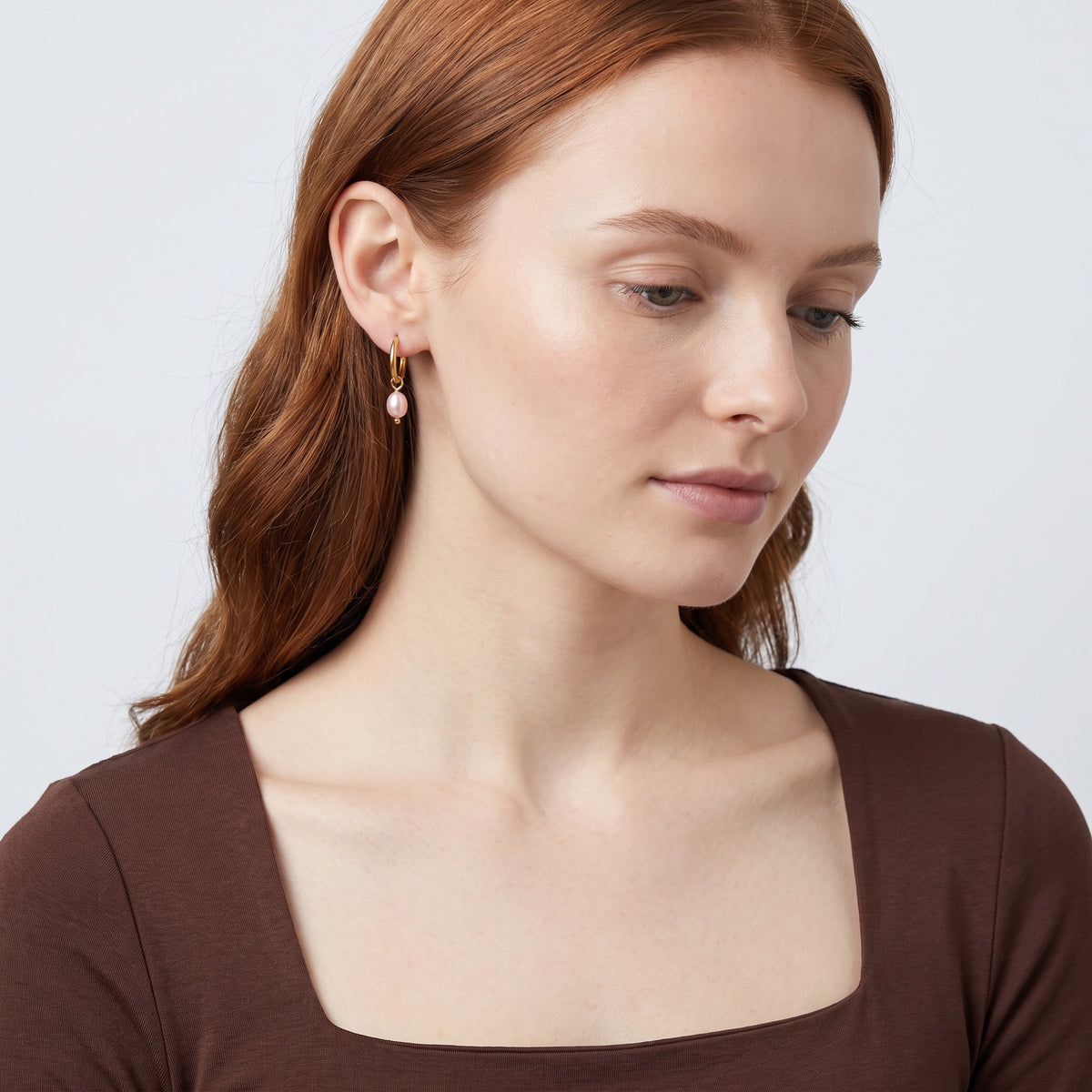 Model wearing the Lelice Marie Pearl Earrings in gold, serene chin lift