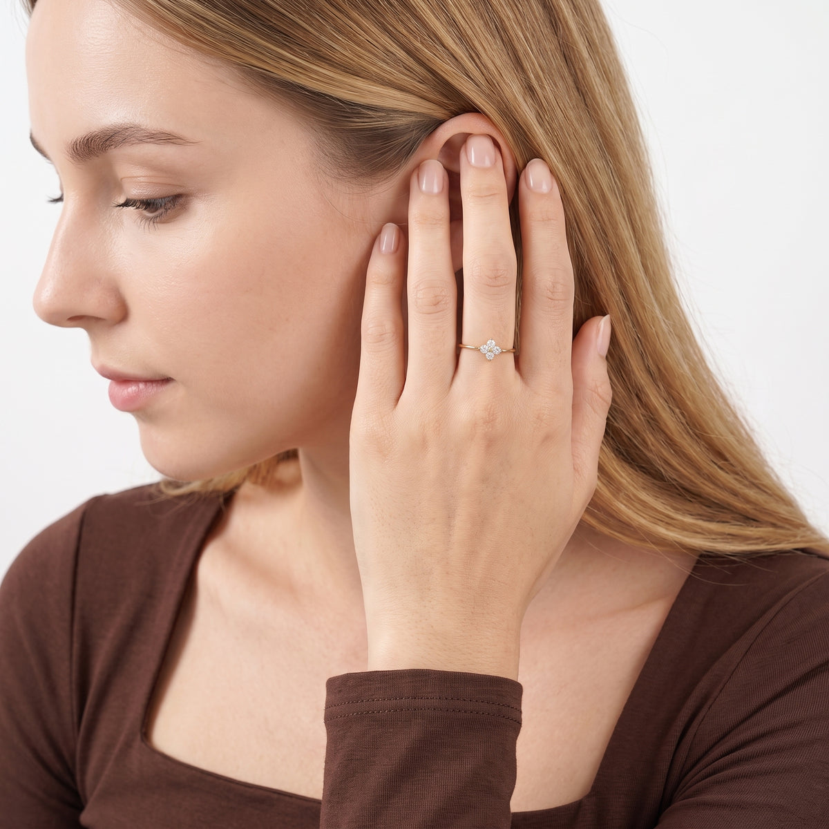 Woman tucking hair behind her ear wearing Mathilde gold clover ring