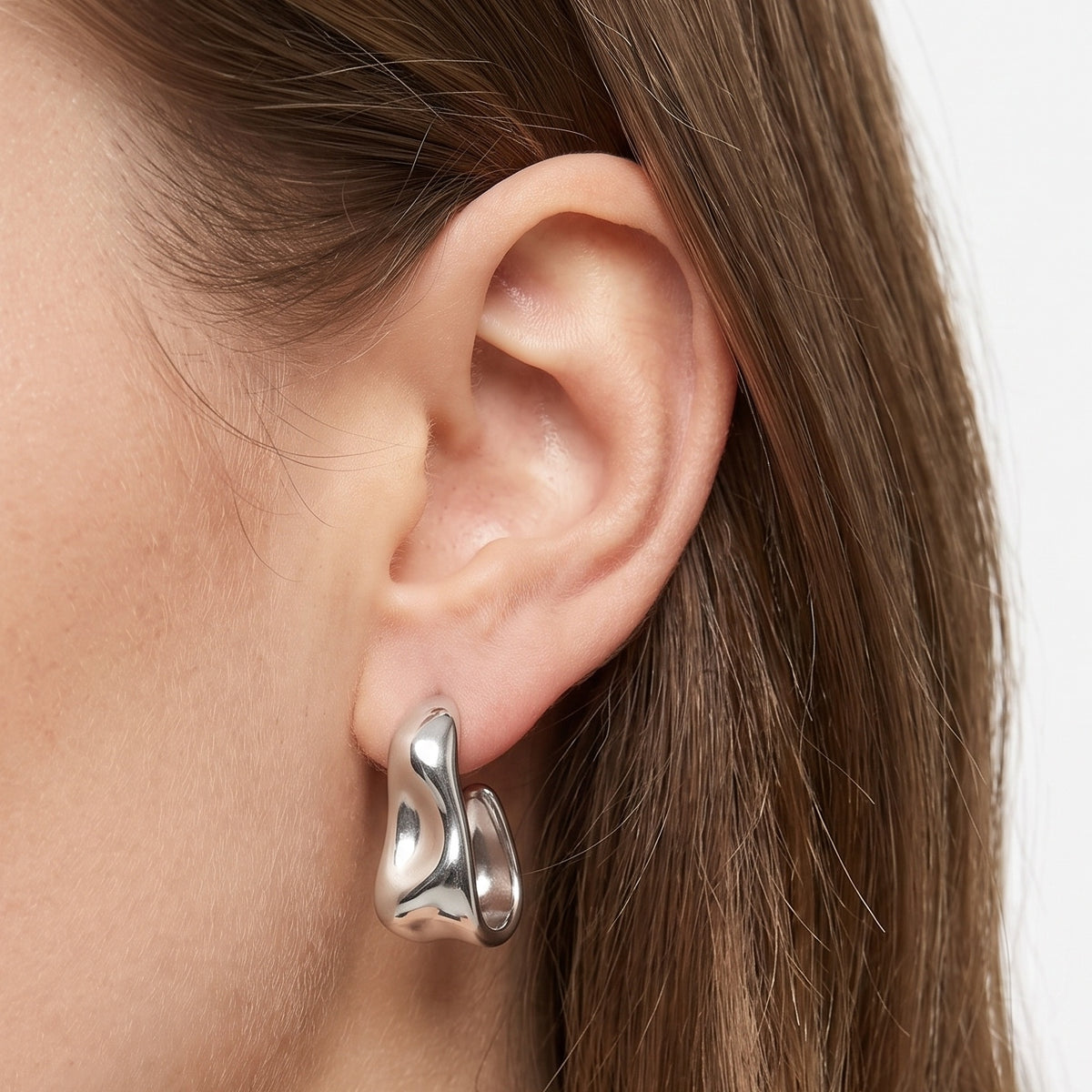 Close-up of the Lelice Maya Ripple Silver Hoops on the ear
