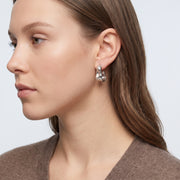Model wearing the Lelice Maya Ripple Silver Hoops, side profile portrait