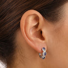 Close-up of the Lelice Midnight Sapphire Hoops in silver on the ear