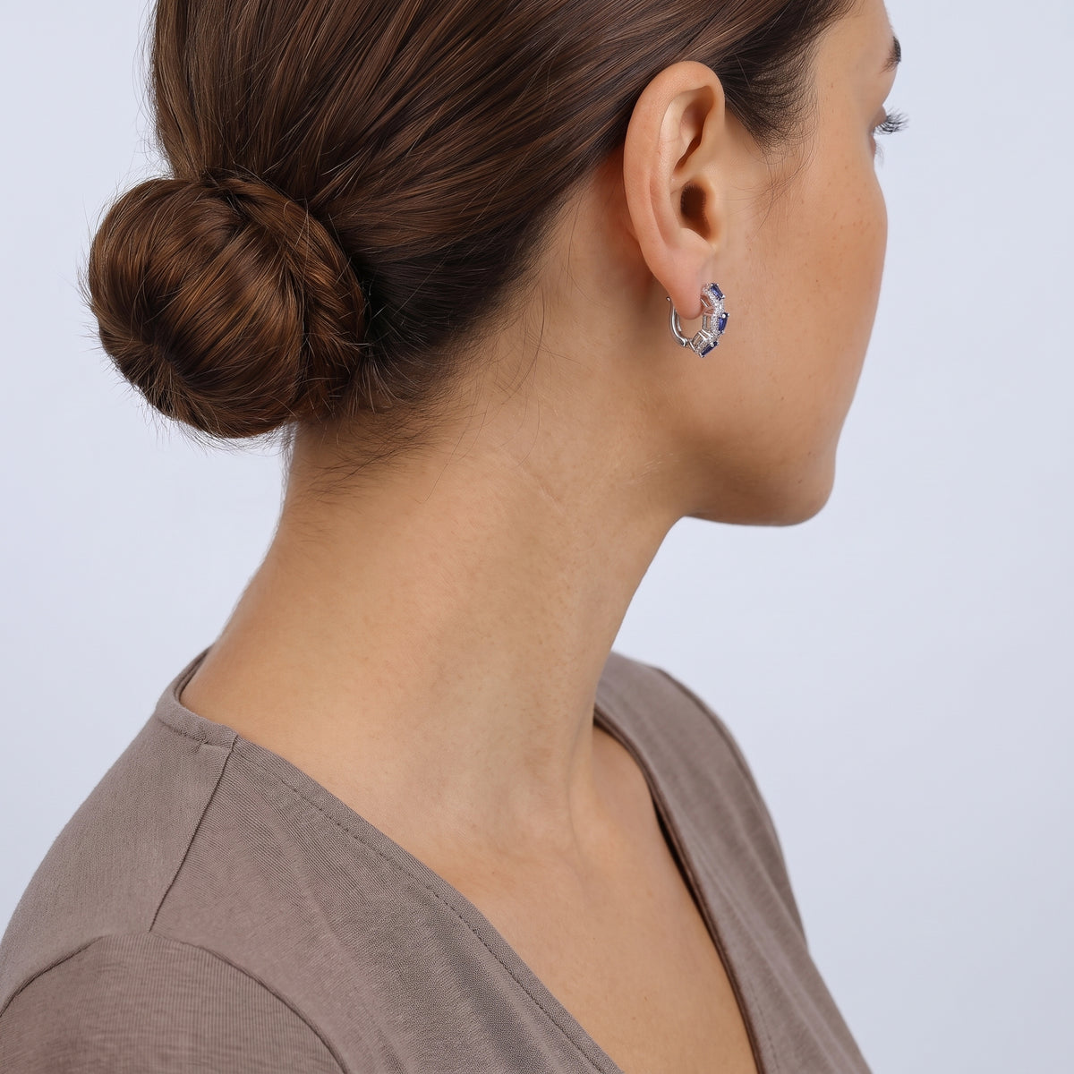Model wearing the Lelice Midnight Sapphire Hoops in silver, low bun, ear and neck