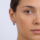 Model wearing the Lelice Midnight Sapphire Hoops in silver, one-eye face close-up