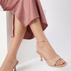 Seated woman with ankles crossed wearing the Mila Herringbone Anklet