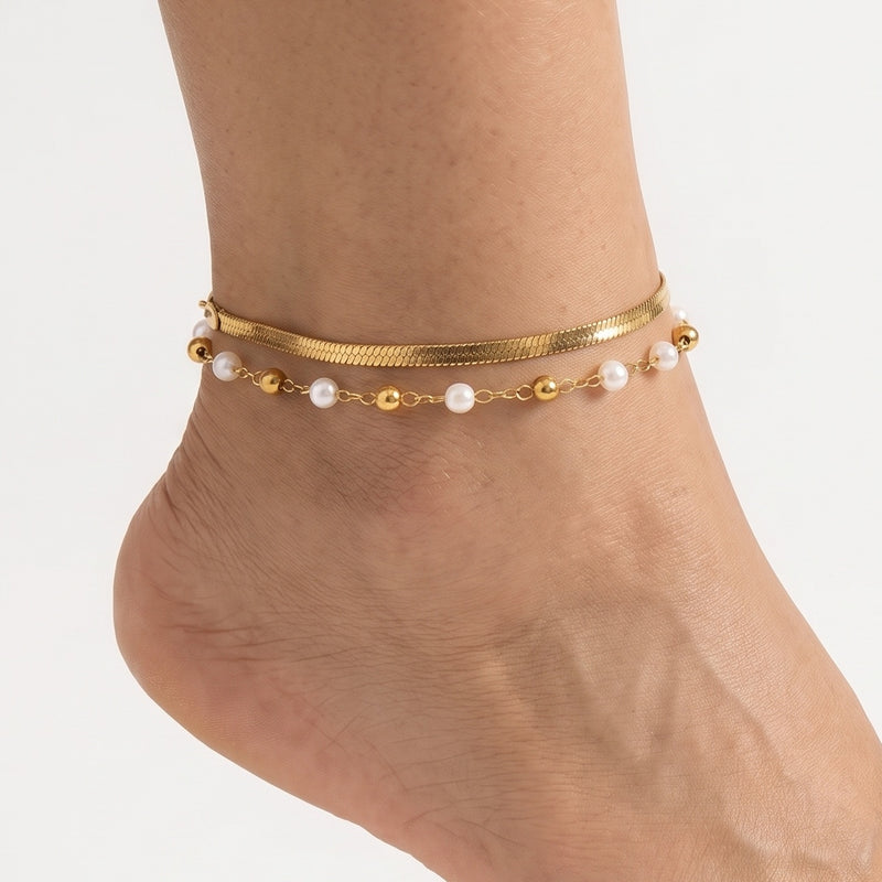 Close-up of the Lelice Mireya Pearl Herringbone Anklet in gold on a woman's ankle