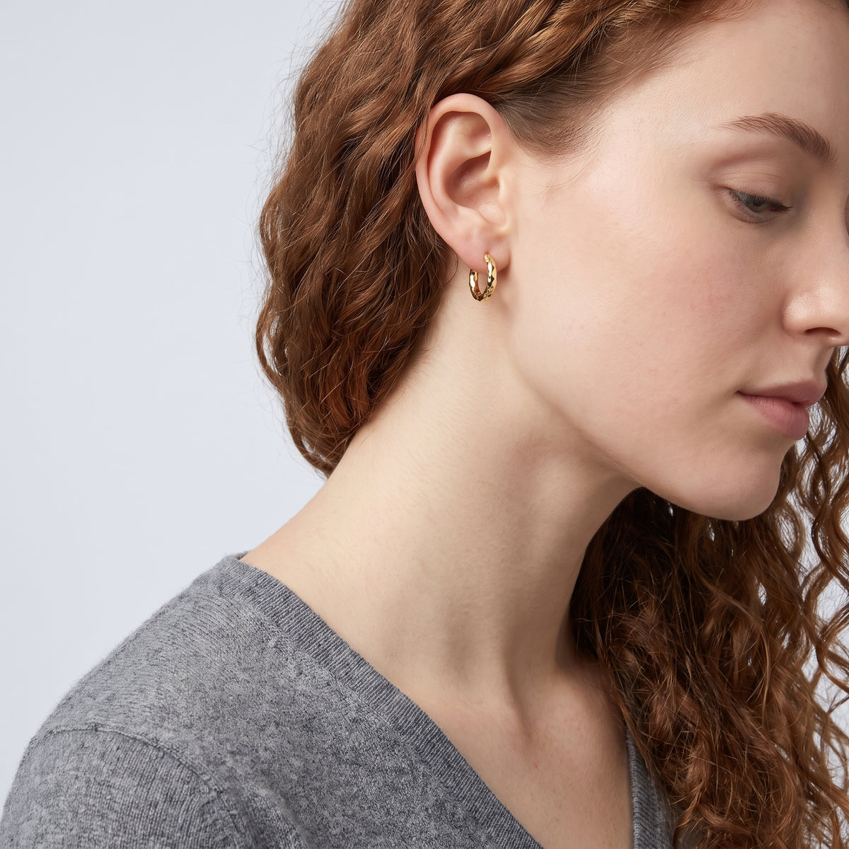 Model wearing the Lelice Molly Hoop Earrings in gold, sculpted side profile