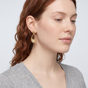 Model wearing the Lelice Nadia Gold Textured Teardrop Statement Earrings, serene chin lift