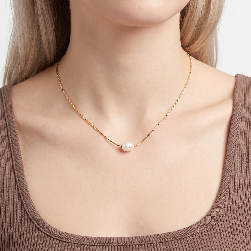 Close-up of the Lelice Nice Pearl Necklace in gold at the collarbone