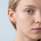 Model wearing the Lelice Nina Petite Studs in gold, one-eye face close-up