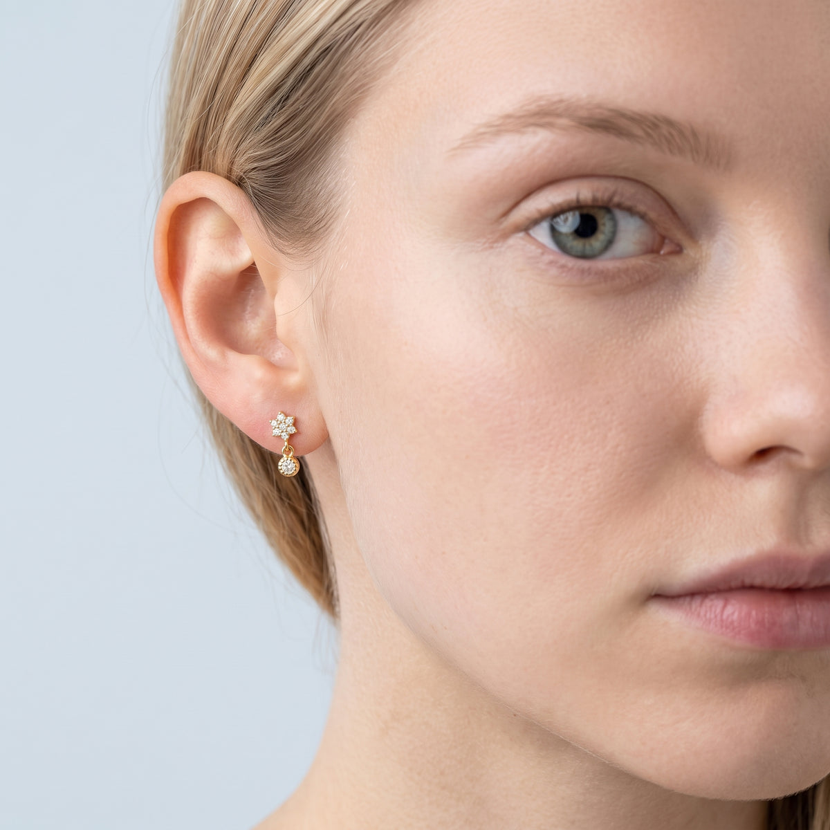 Model wearing the Lelice Nina Petite Studs in gold, one-eye face close-up