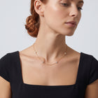 Neckline profile with hair up, wearing the Noémie Crystal Necklace