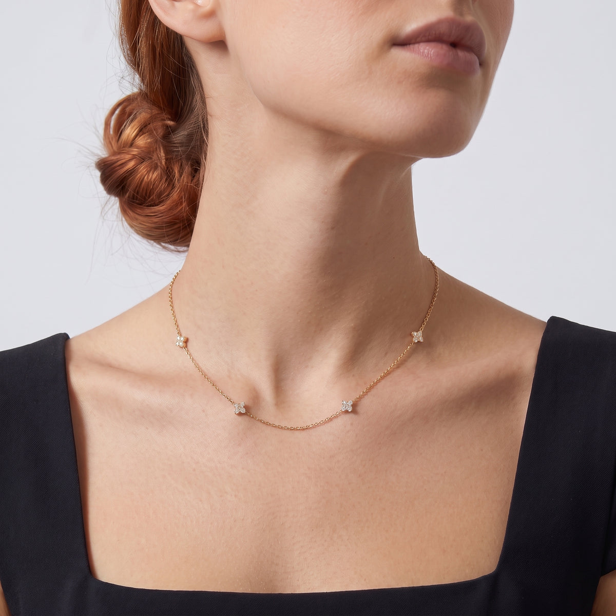 Low-angle portrait of a woman wearing the Noémie Crystal Necklace