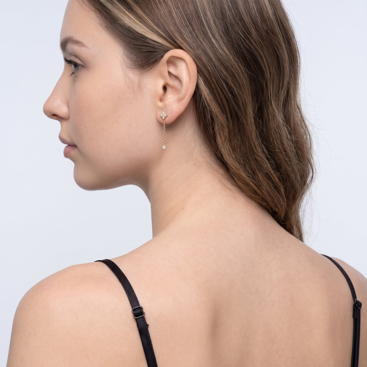 Model wearing the Lelice Noémie Drop Earrings in gold, three-quarter back view