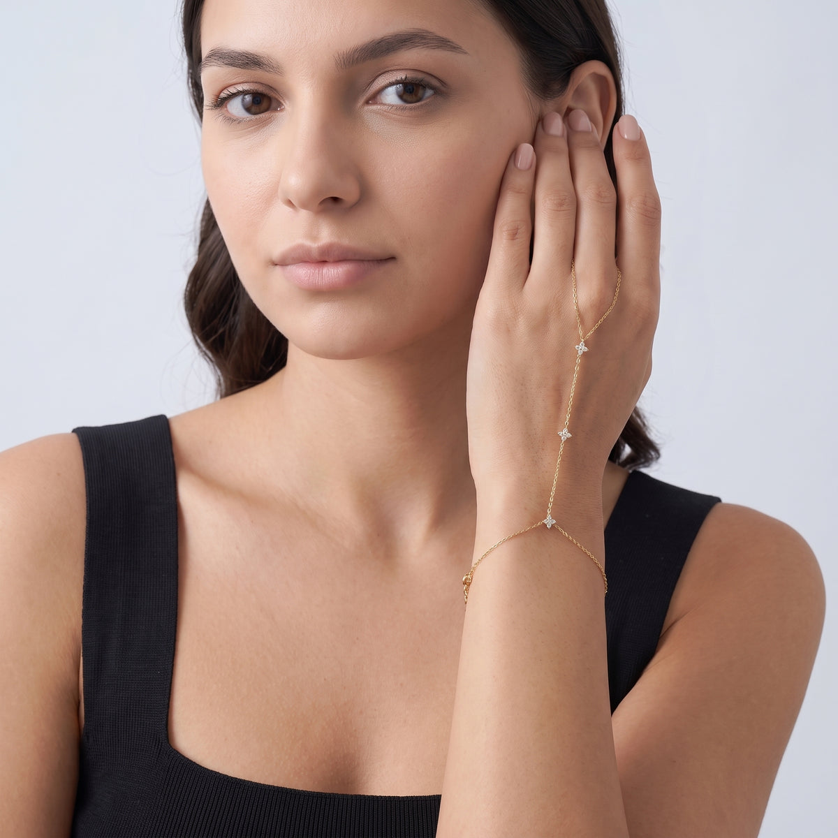 Model wearing the Lelice Noémie Fine Bracelet in gold, hand at the face