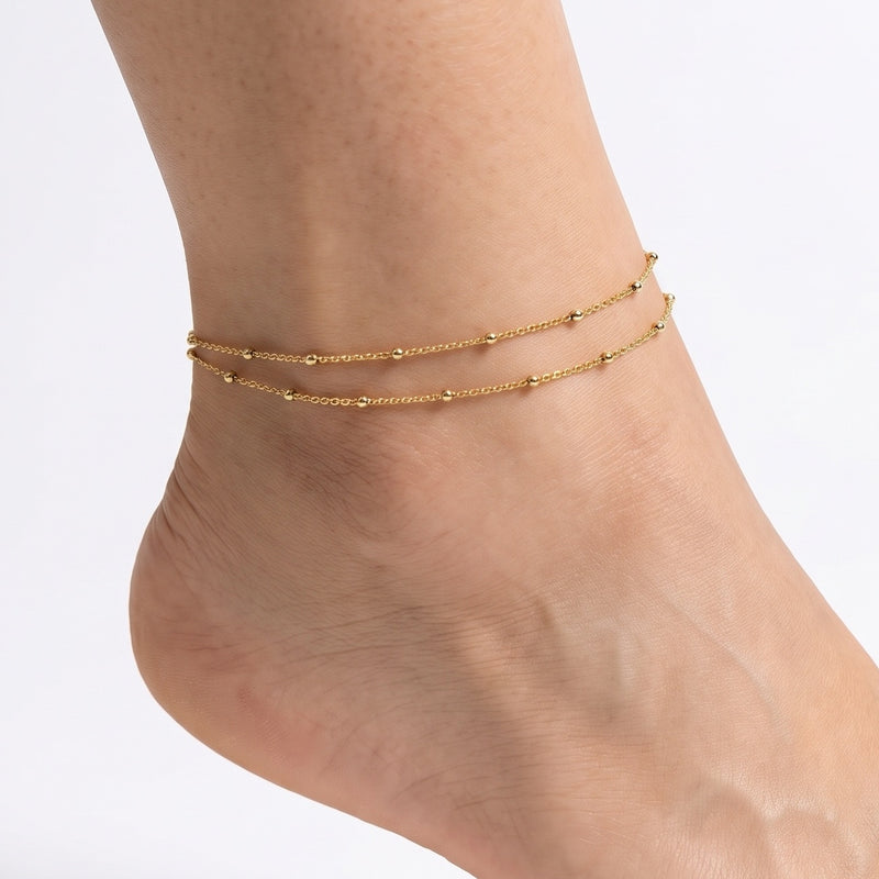 Close-up of the Lelice Nova Layered Anklet in gold on a woman's ankle