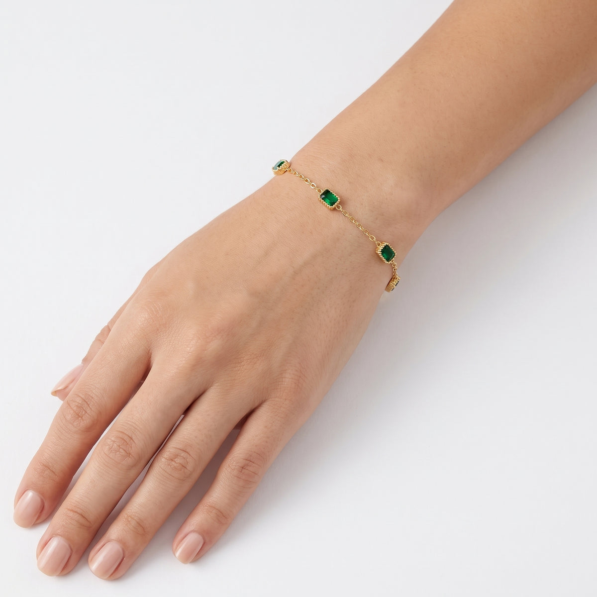 Wrist wearing Lelice gold emerald green station bracelet Olive