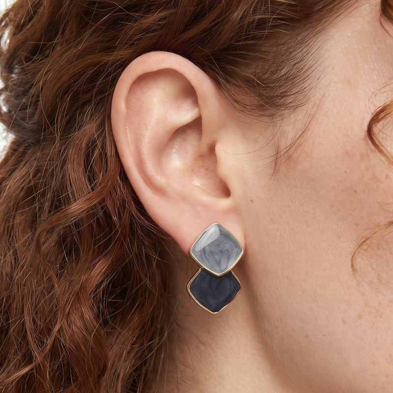 Close-up of the Lelice Ondine Blue Marbled Earrings in gold on the ear