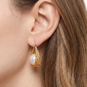 Close-up of the Lelice Pearl Nest Hoops in gold on the ear