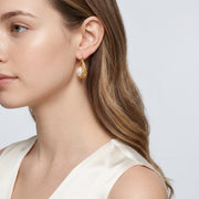 Model wearing the Lelice Pearl Nest Hoops in gold, three-quarter back view