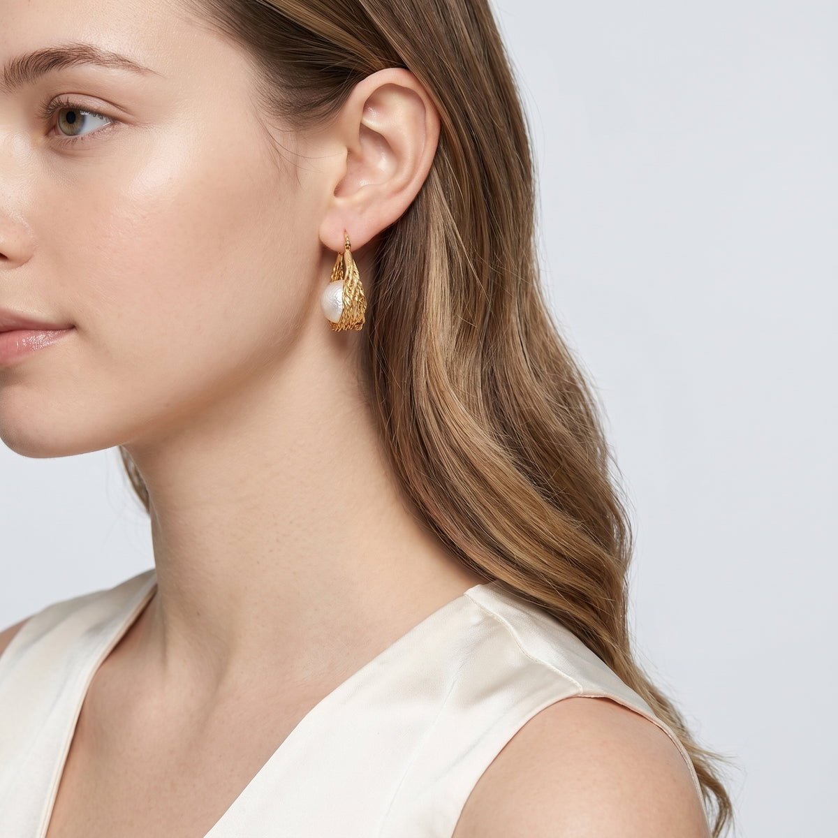 Model wearing the Lelice Pearl Nest Hoops in gold, three-quarter back view