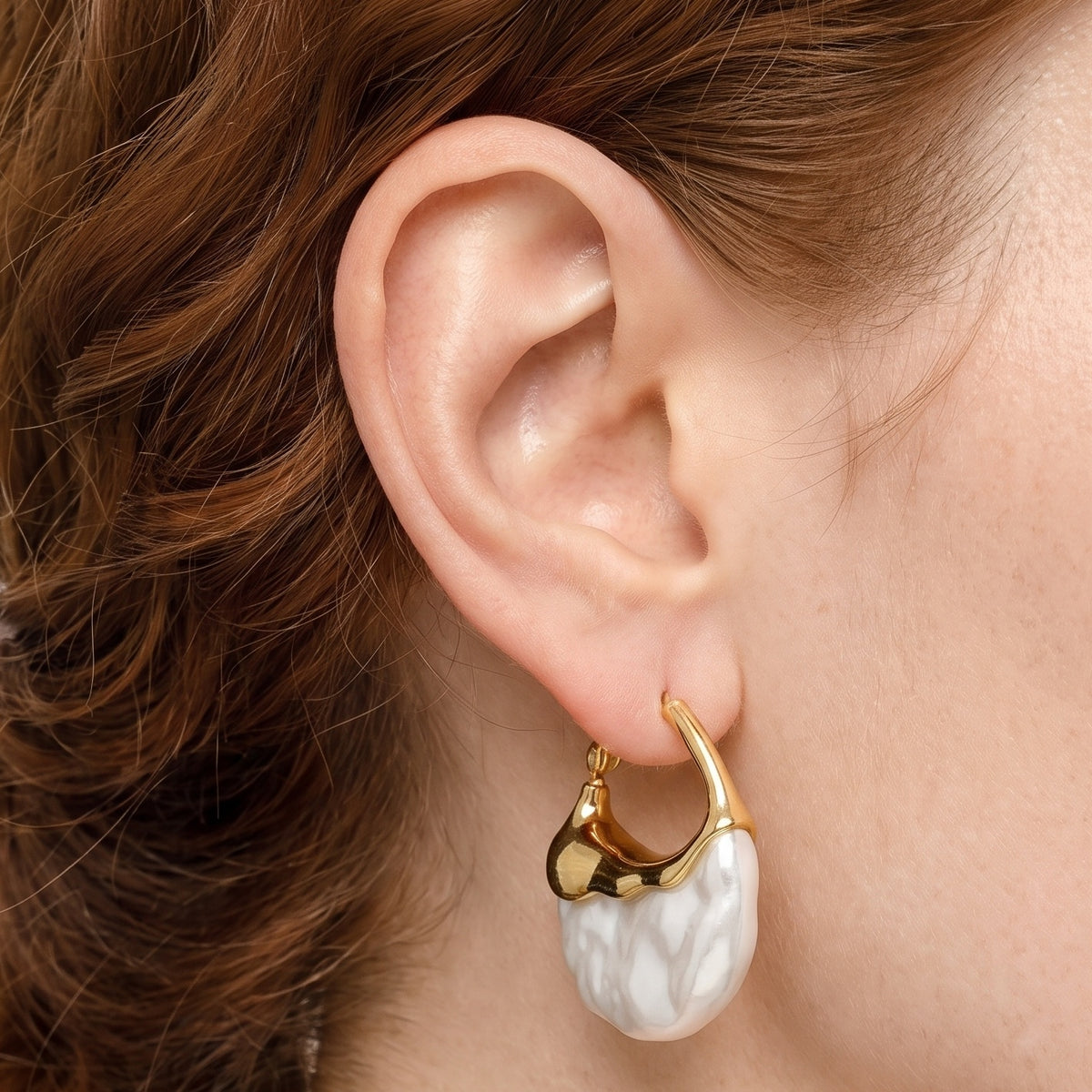 Close-up of the Lelice Perla Gold Baroque Pearl Chunky Hoop Earrings on the ear