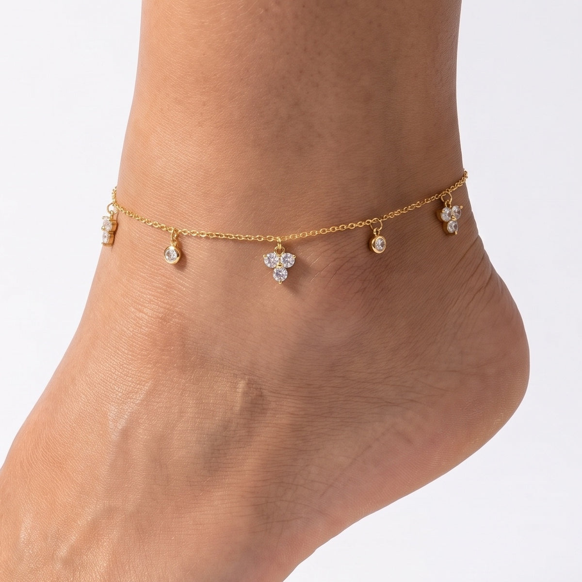 Close-up of the Lelice Petite Bloom Anklet in gold on a woman's ankle