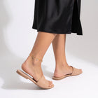 Woman walking away in the Petite Bloom Anklet, heel lifted