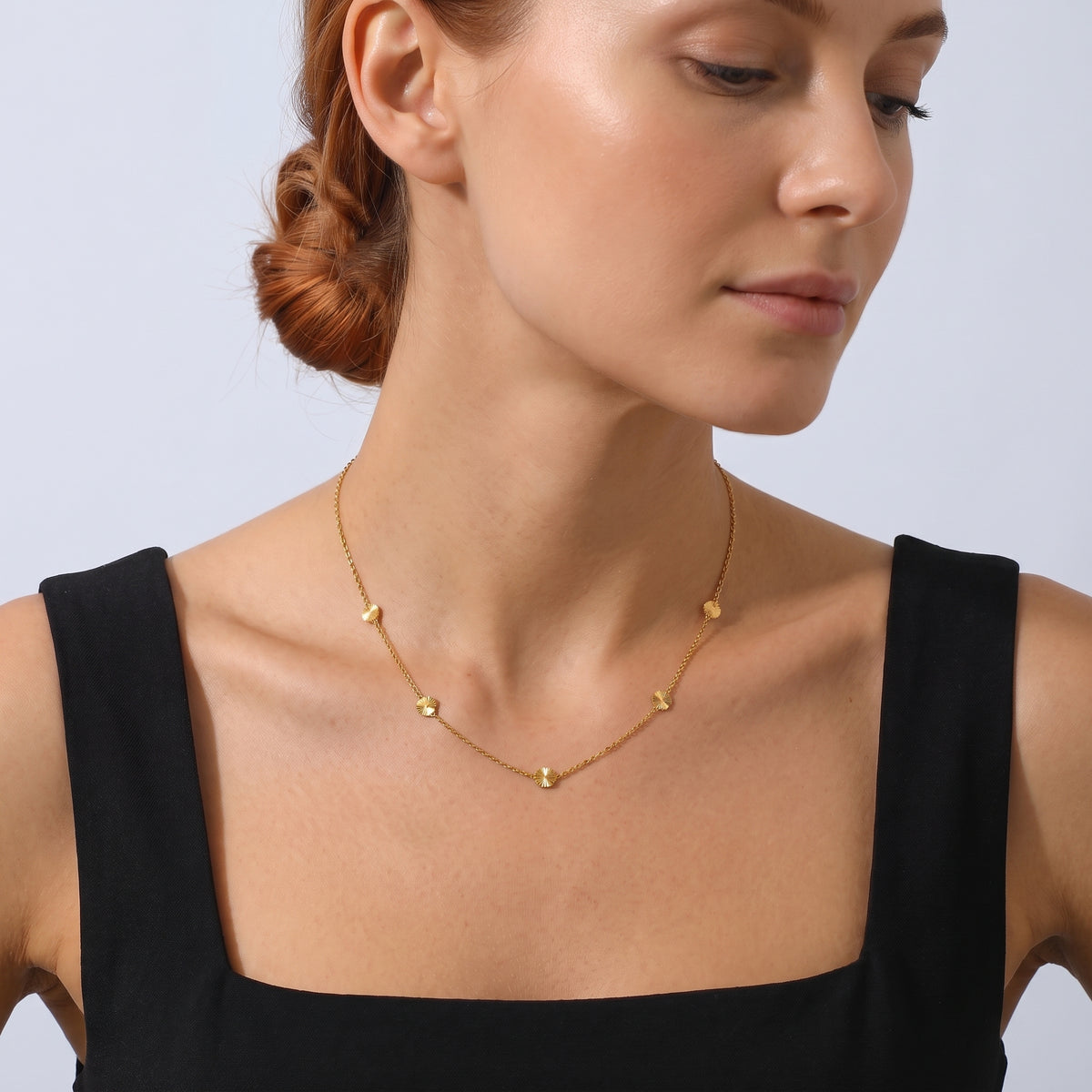 Neckline profile with hair up, wearing the Petite Blossom Necklace