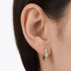 Close-up of the Lelice Petite Luxe Huggies in gold on the ear