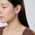 Model wearing the Lelice Petite Luxe Huggies in gold, turned toward the light