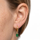 Close-up of the Lelice Piper Emerald Earrings in gold on the ear