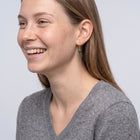 Model wearing the Lelice Piper Emerald Earrings in gold, candid laugh