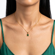 Close-up of the Lelice Piper Emerald Necklace in gold at the collarbone