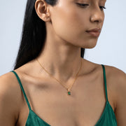 Three-quarter profile of a woman wearing the Piper Emerald Necklace