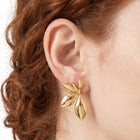 Close-up of the Lelice Puffy Petal Statement Studs in gold on the ear