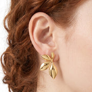 Close-up of the Lelice Puffy Petal Statement Studs in gold on the ear